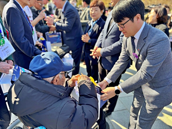 지난 11일 부산 유엔기념공원에서 열린 ‘턴 투워드 부산(Turn Toward Busan)’ 행사에 참석한 김태우 롯데웰푸드 CSR마케팅팀 팀장이 참전용사에게 감사 키트를 전달하고 있다(사진=롯데웰푸드)