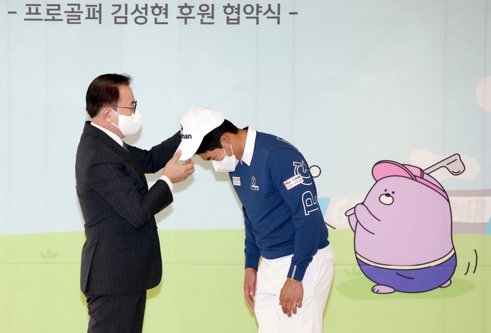 조용병 회장(왼쪽)이 김성현 선수에게 신한금융그룹 모자를 직접 씌워주는 모습. (사진=신한금융)